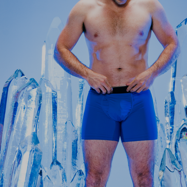 Standing among towering ice crystals against a pale blue sky in royal blue Shinesty boxer briefs